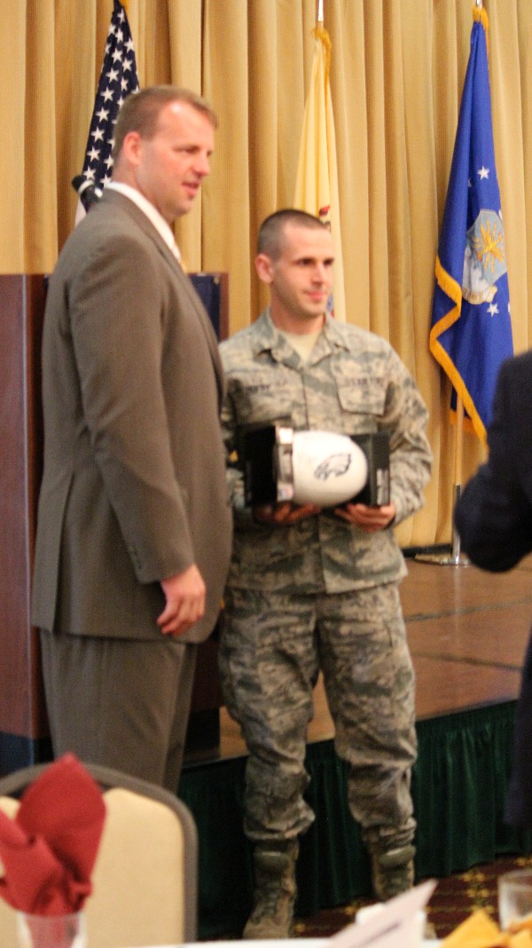 Runyan (l) presents Senior Airman Brenan Duffy, USAF, with a football in honor of his Airman of the Year Award at the chapter's May meeting.